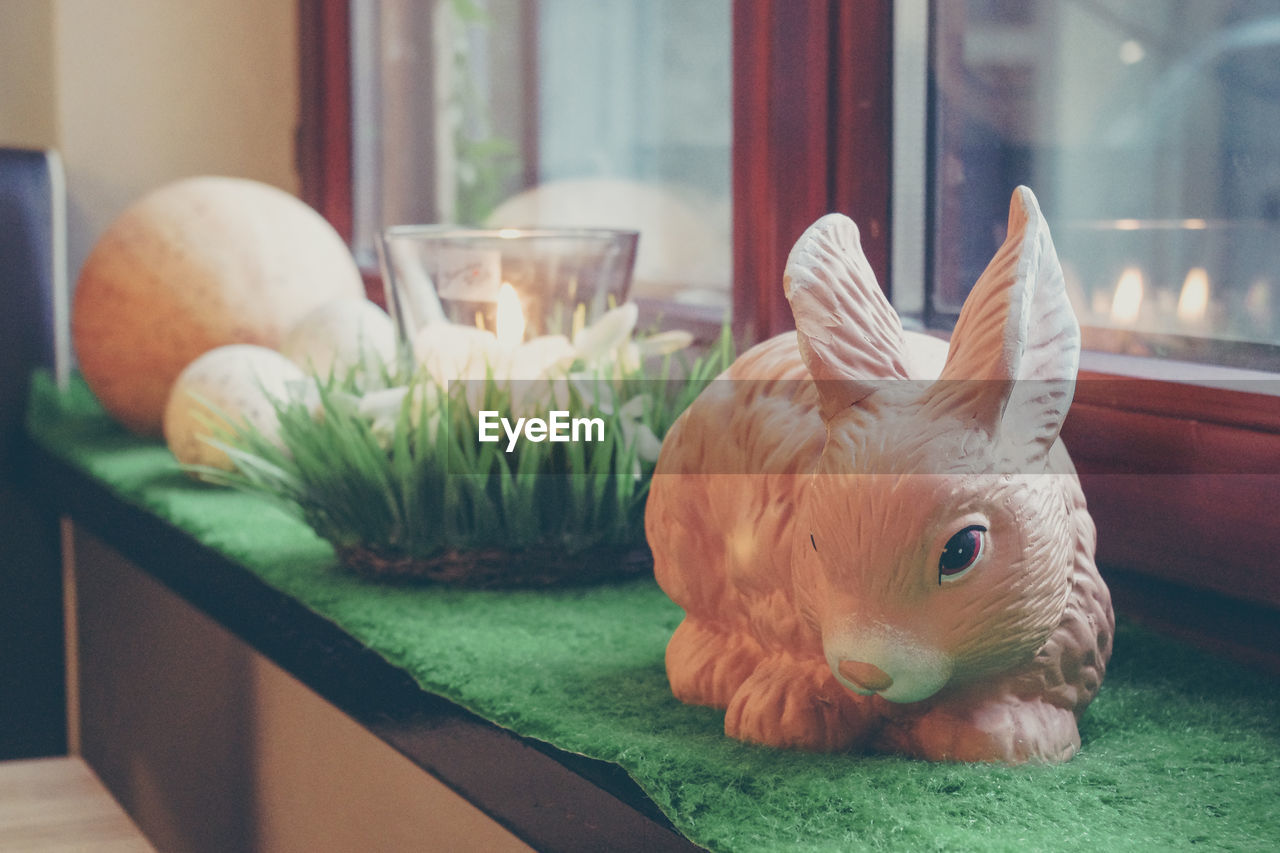 Close-up of easter bunny on table by window at home