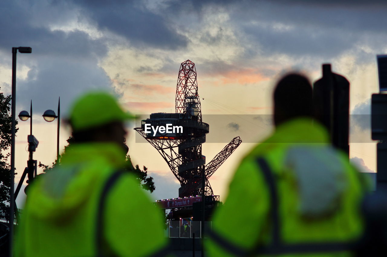 Rear view of workers looking at rig