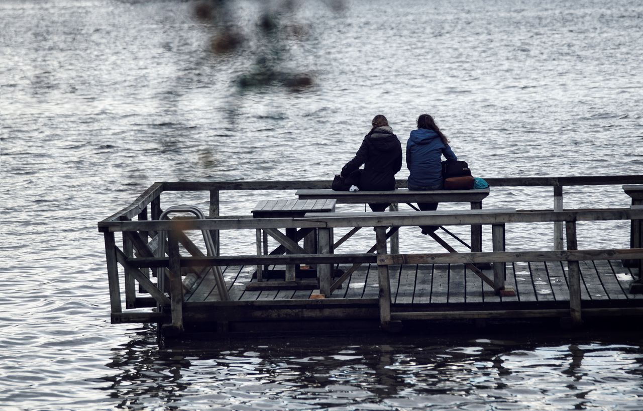 People sitting on pier at beach