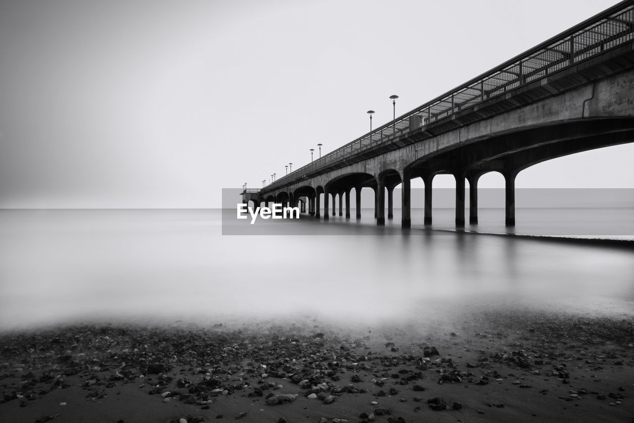 Bridge over sea against clear sky