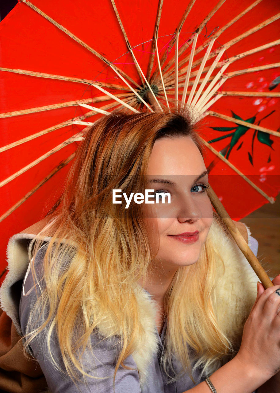 PORTRAIT OF YOUNG WOMAN WITH RED UMBRELLA