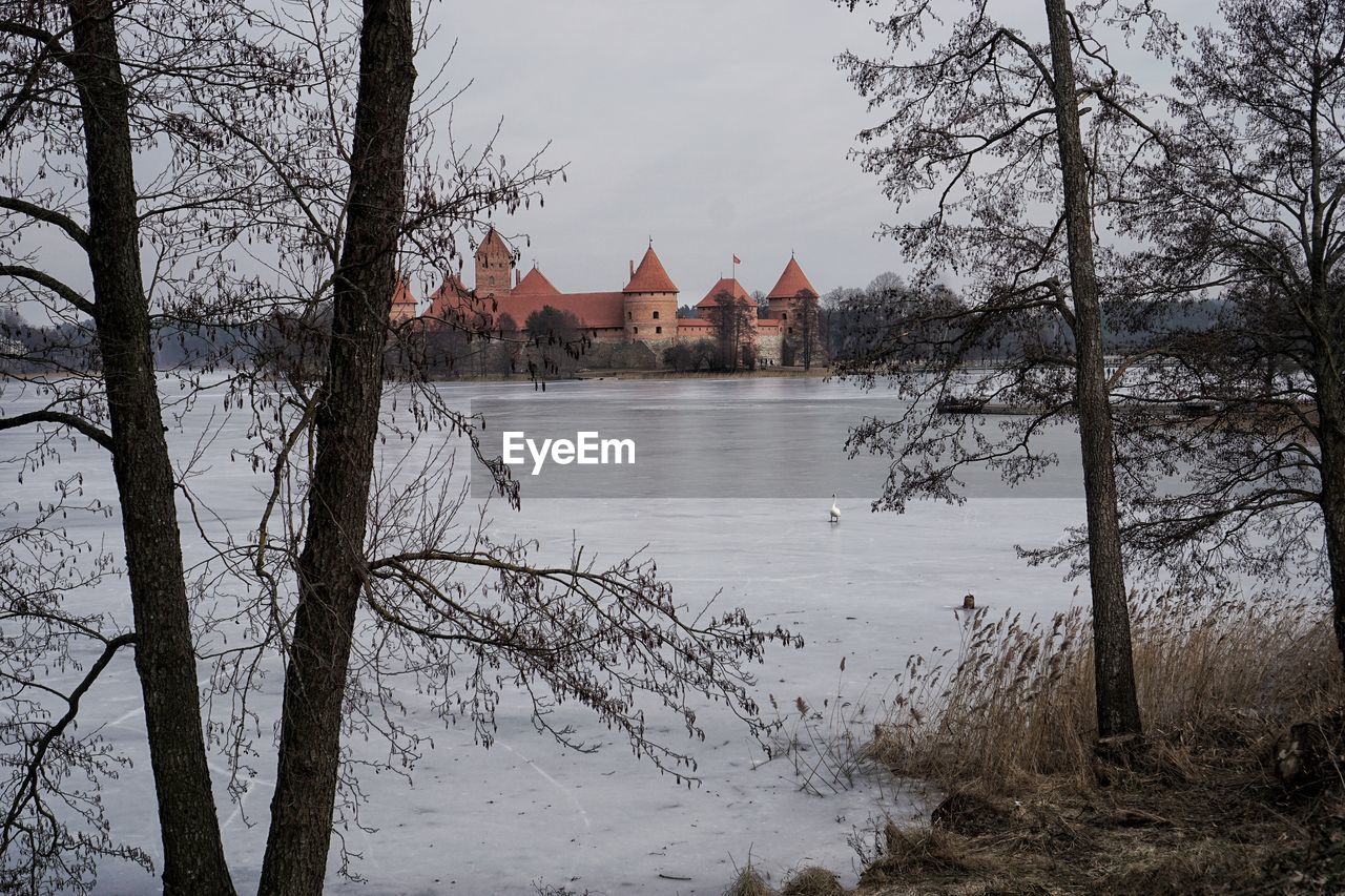 SCENIC VIEW OF LAKE BY BUILDING AGAINST SKY