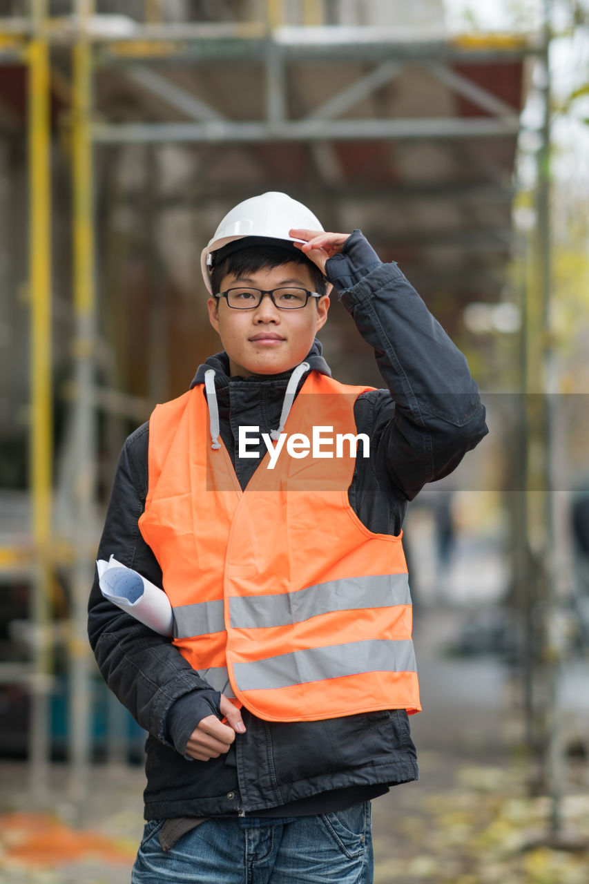 Portrait of engineer in reflective clothing standing outdoors