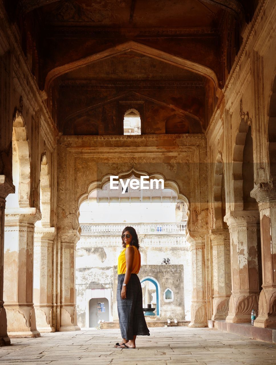 Side view of woman standing in historic building