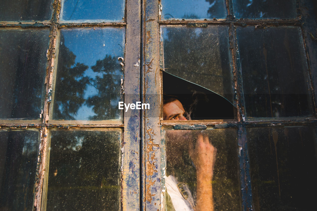 Man looking through window