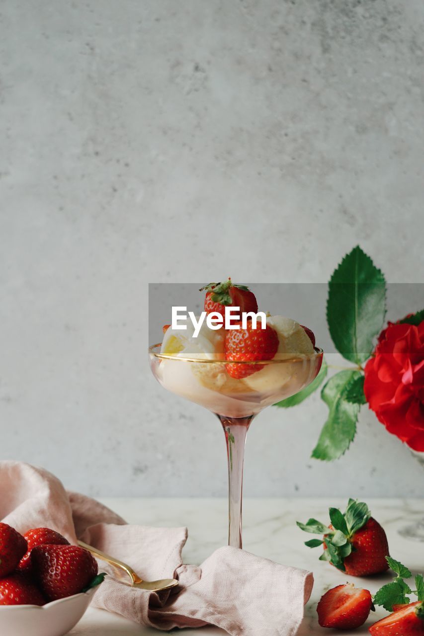 Close-up of strawberry and icecream served on table