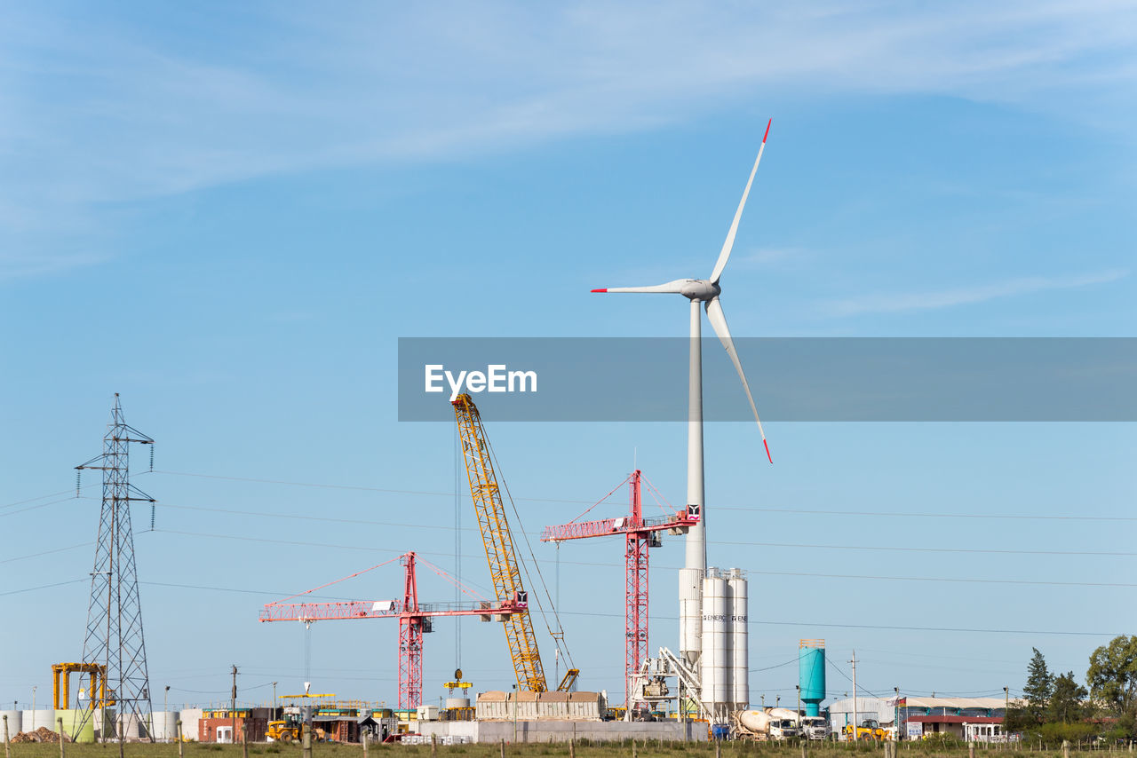 power generation, renewable energy, sky, wind turbine, wind power, turbine, alternative energy, environmental conservation, technology, environment, electricity, nature, windmill, wind farm, industry, machine, power supply, day, architecture, cloud, environmental issues, machinery, built structure, blue, outdoors, transportation, field, wind, landscape, sustainable resources, no people, cable, mill, grass, development, sunlight, clear sky, mast