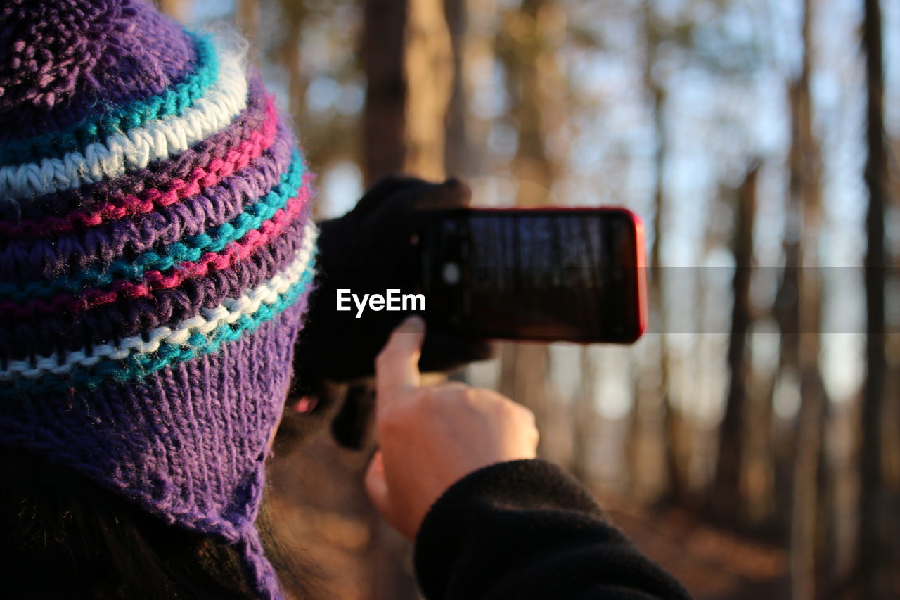 Close-up of person photographing with mobile phone in winter