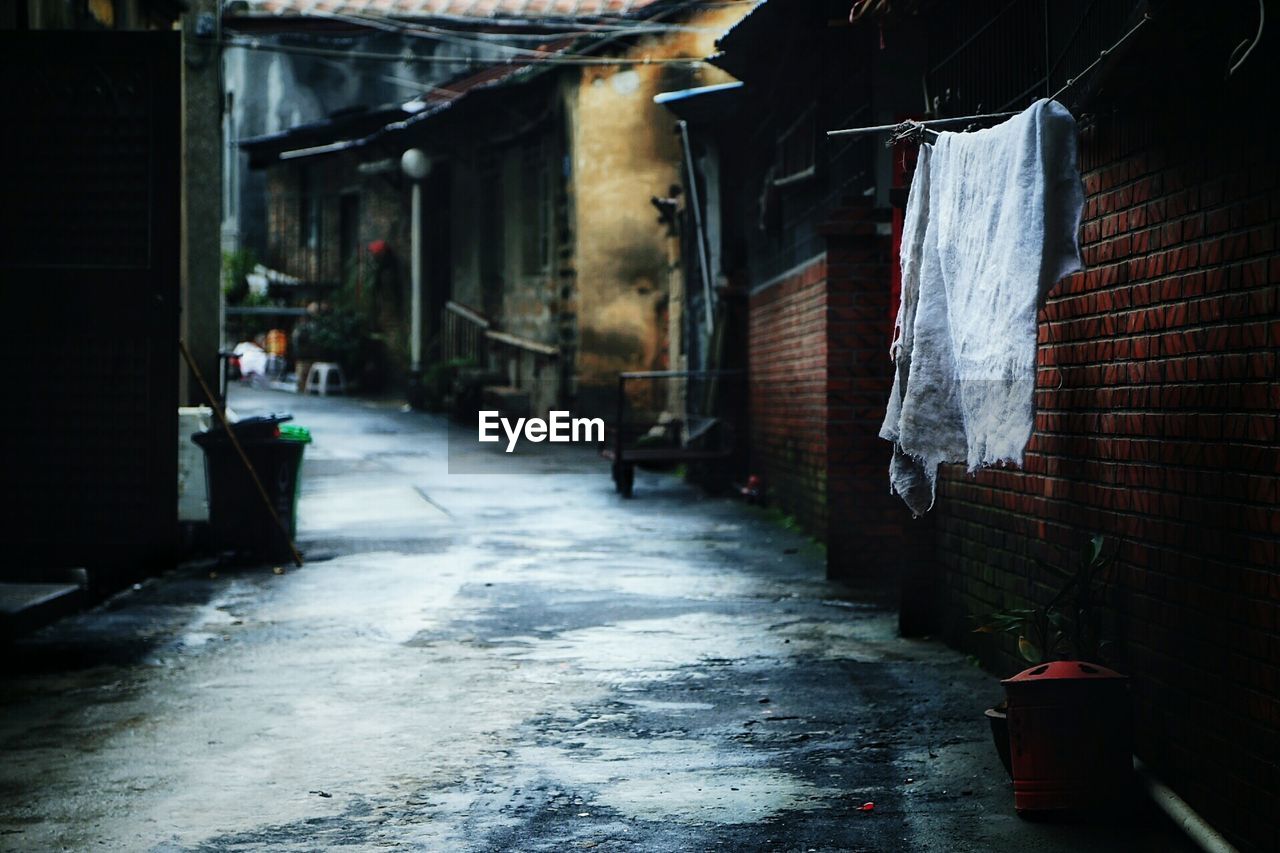 Alley amidst old houses during rainy season