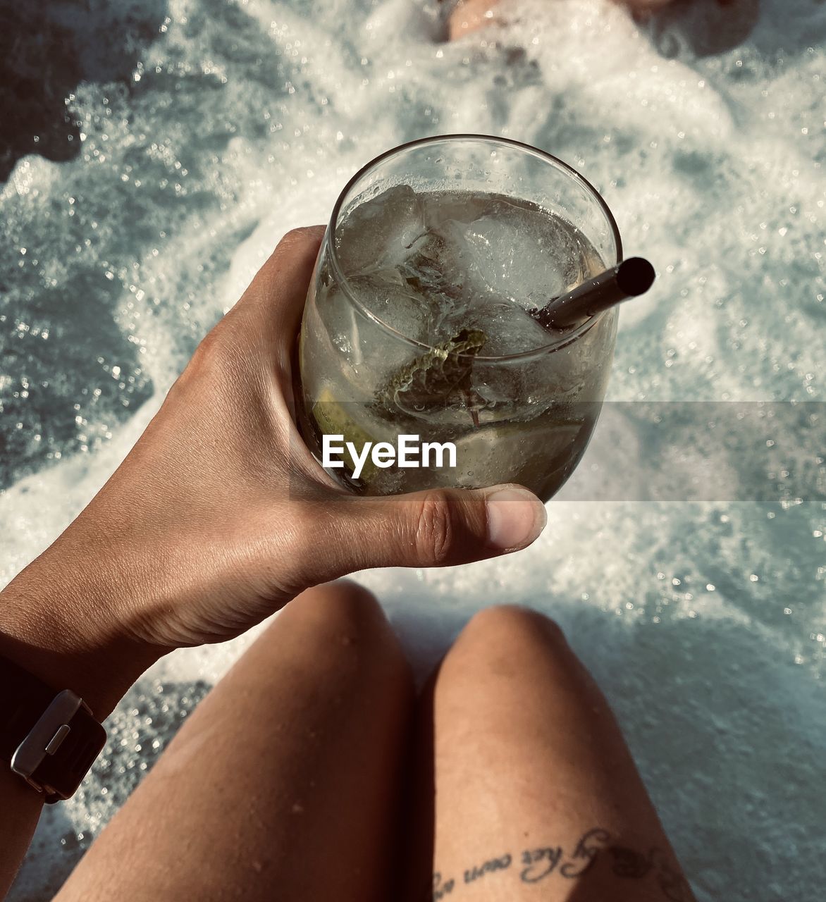 MIDSECTION OF WOMAN DRINKING WATER FROM GLASS