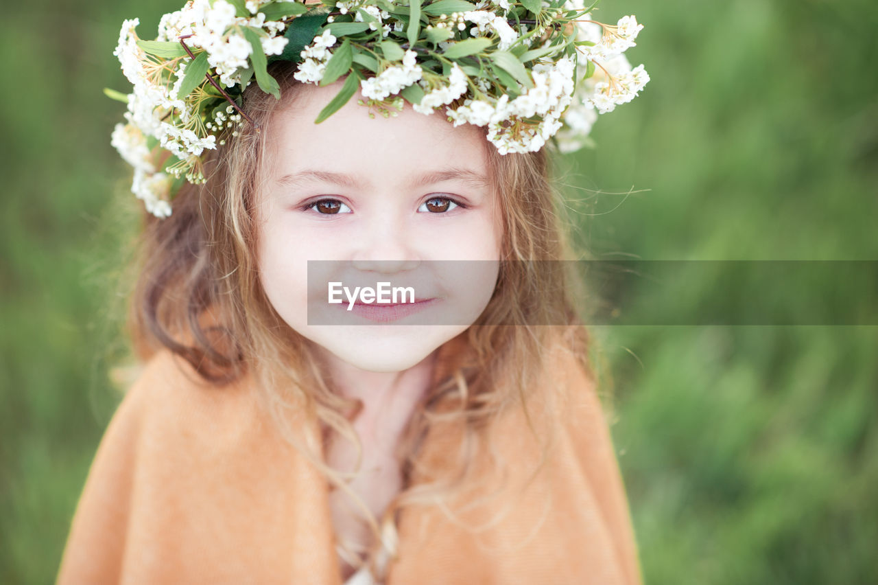 Portrait of girl wearing wreath at park