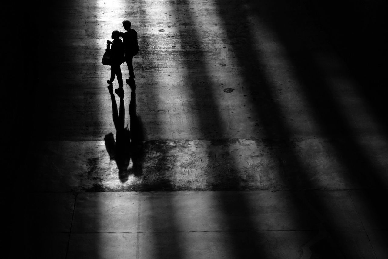 SILHOUETTE MAN WALKING ON ROAD WITH SHADOW ON THE BACKGROUND