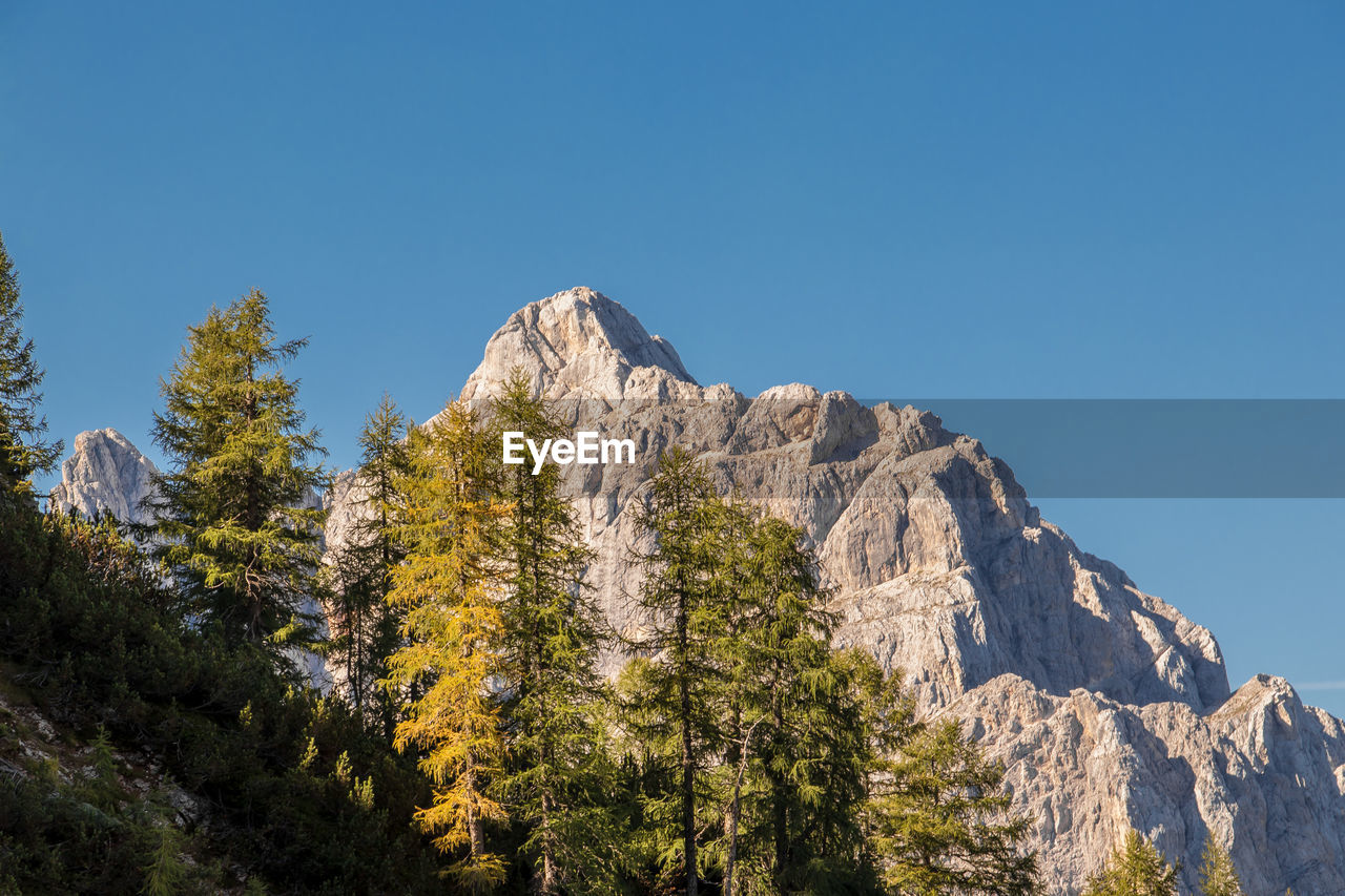 Low angle view of mountain against clear blue sky