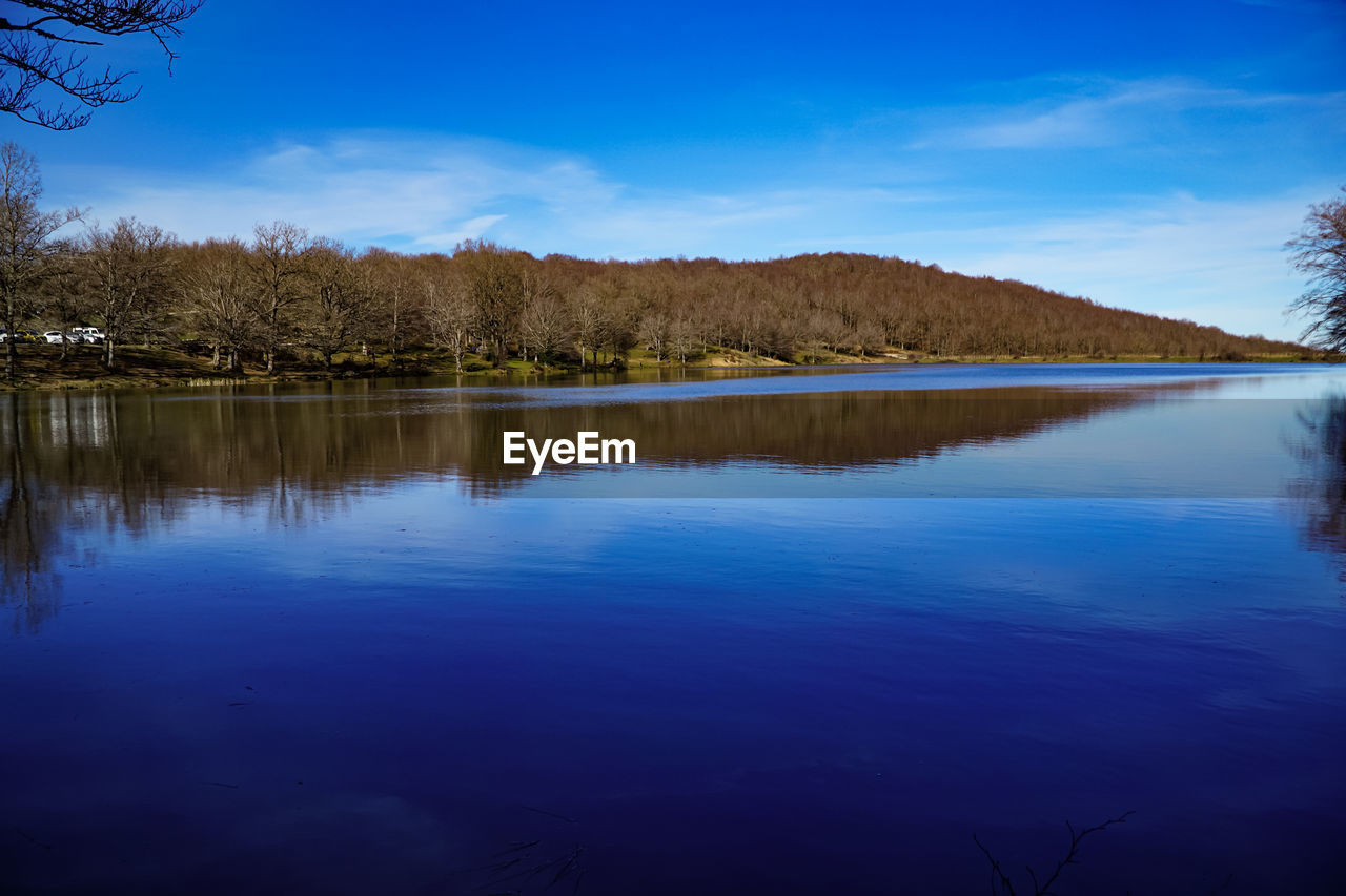 reflection, water, tree, sky, nature, lake, scenics - nature, plant, beauty in nature, tranquility, tranquil scene, blue, body of water, no people, landscape, dusk, environment, morning, land, reservoir, forest, cloud, mountain, non-urban scene, outdoors, travel destinations, wilderness, idyllic, day, pine tree, travel