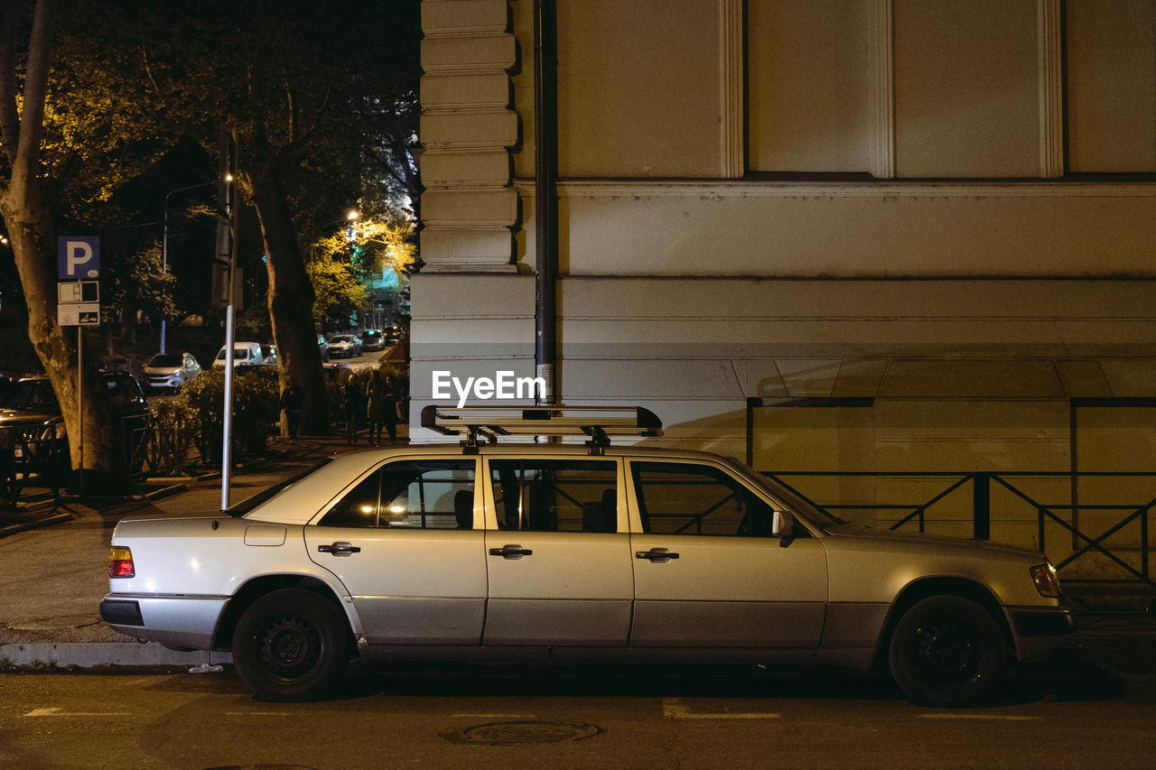 CAR PARKED ON STREET BY BUILDING