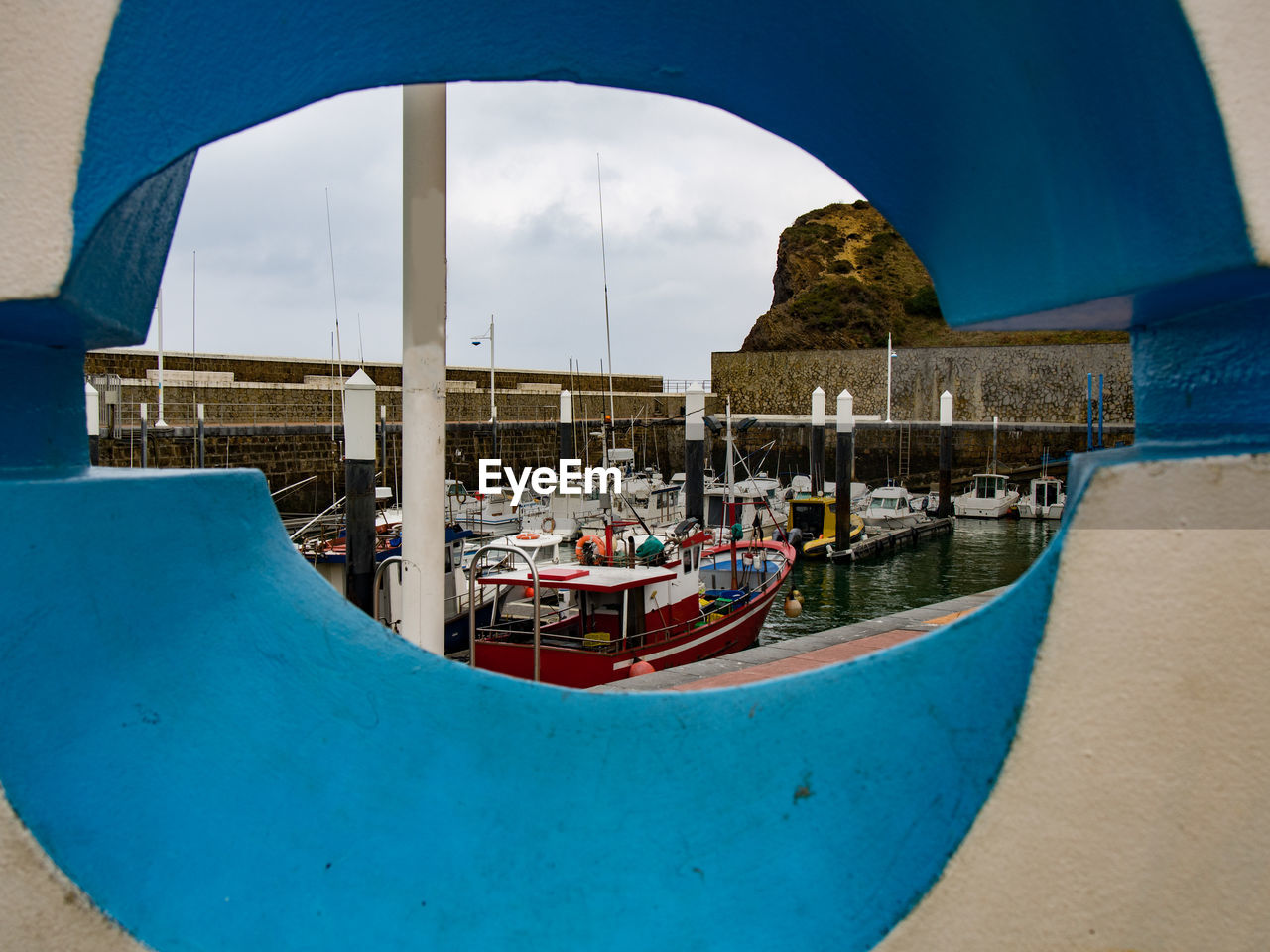 BOATS MOORED AT HARBOR AGAINST SKY