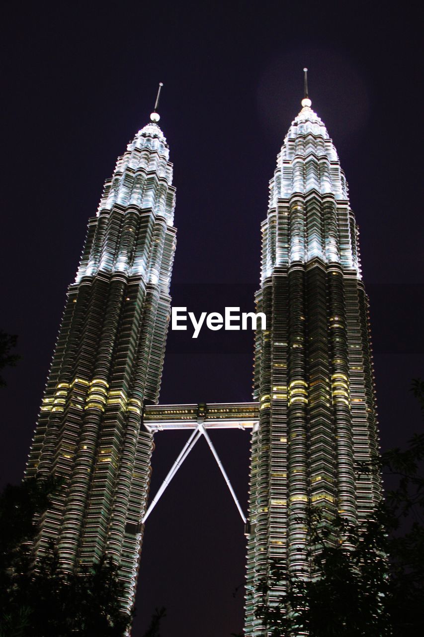 LOW ANGLE VIEW OF MODERN BUILDINGS AGAINST SKY AT NIGHT