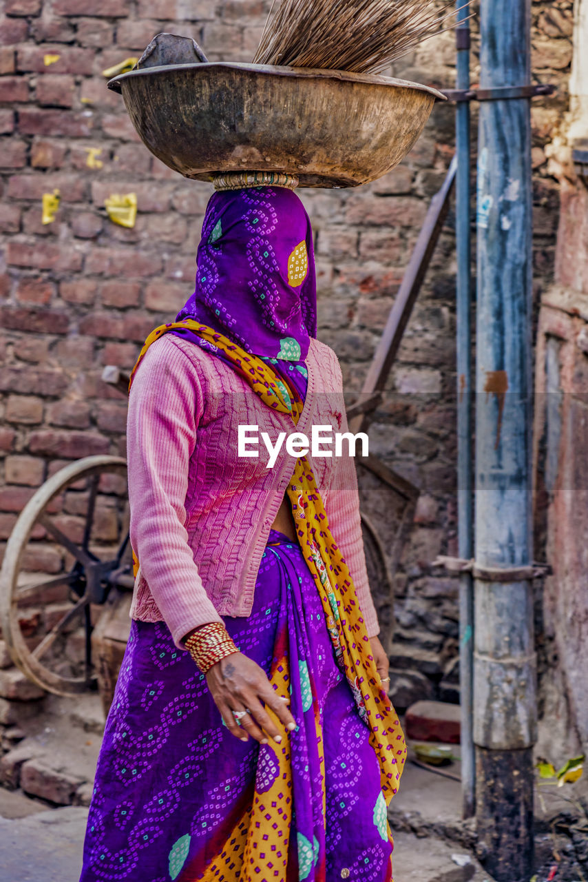 Woman standing against brick wall