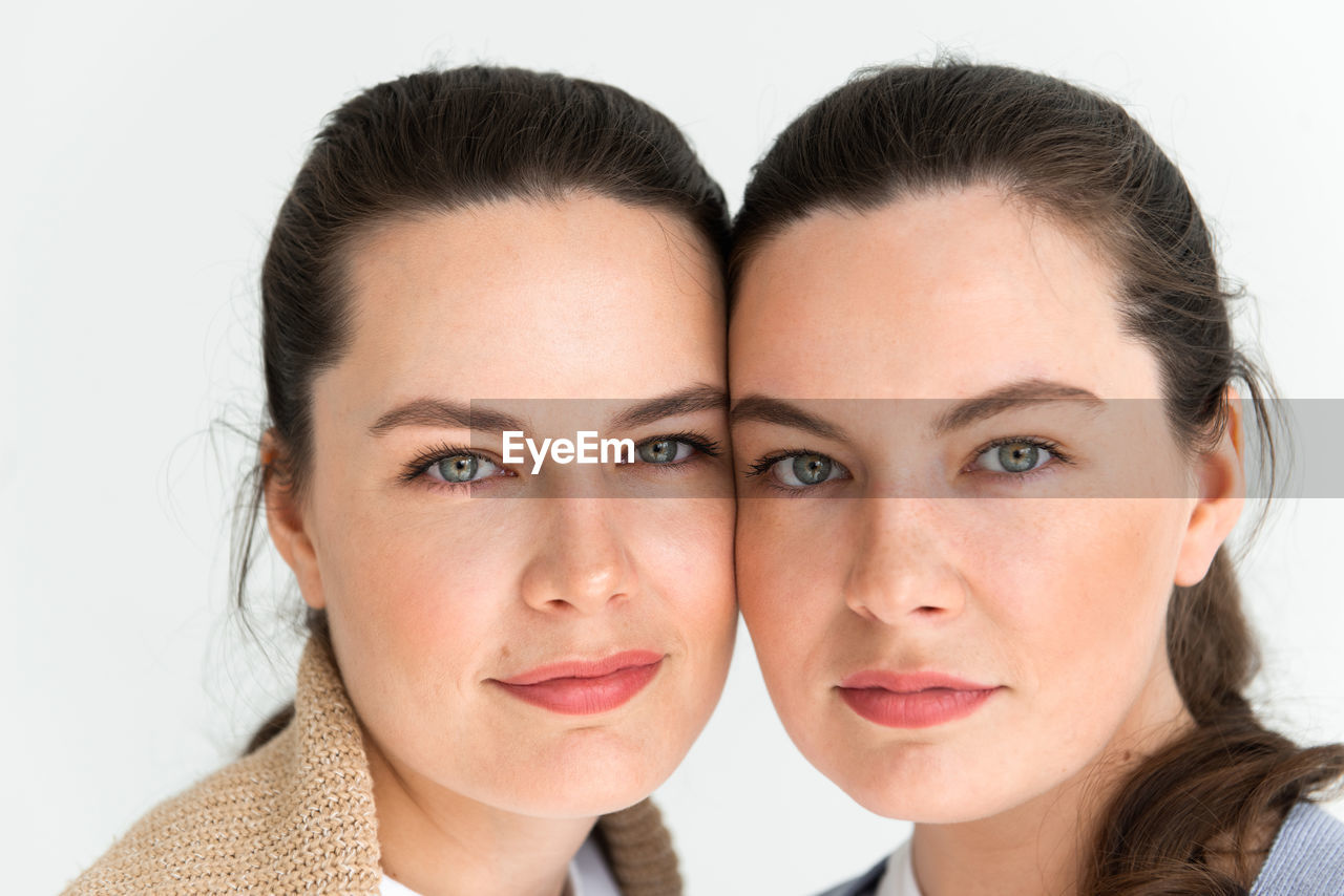 Two beautiful women twin sisters close-up face portrait