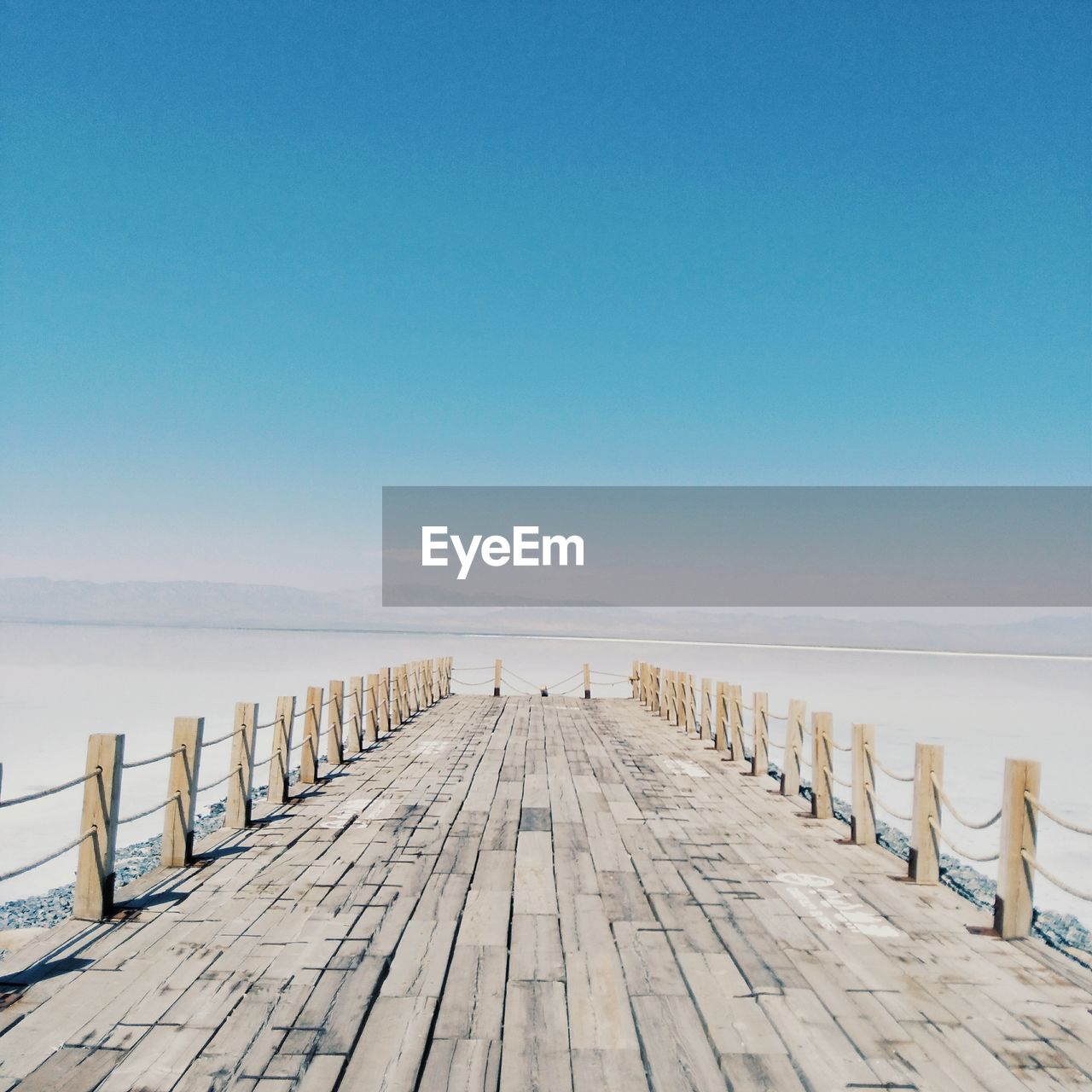 Pier over sea against blue sky