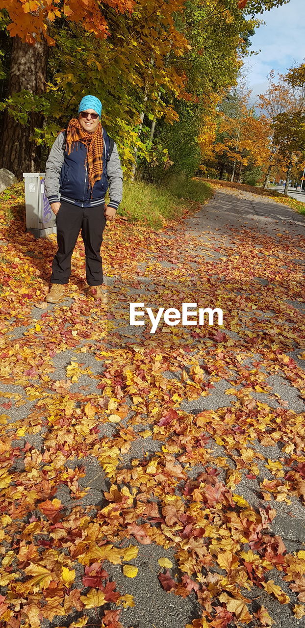 MAN WITH UMBRELLA DURING AUTUMN LEAVES