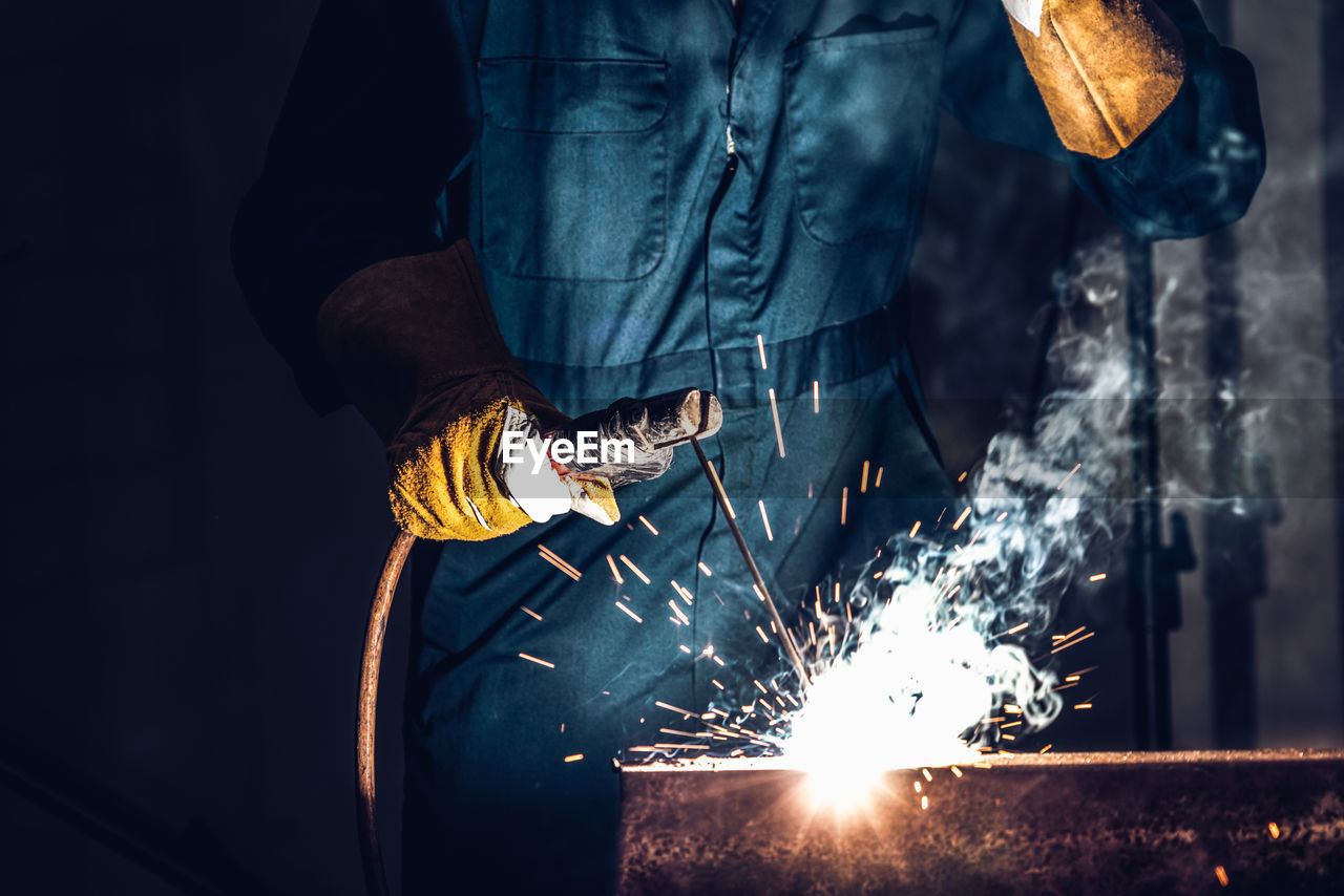 Midsection of man working on fire