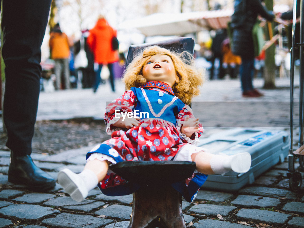 Abandoned doll on cobblestone street