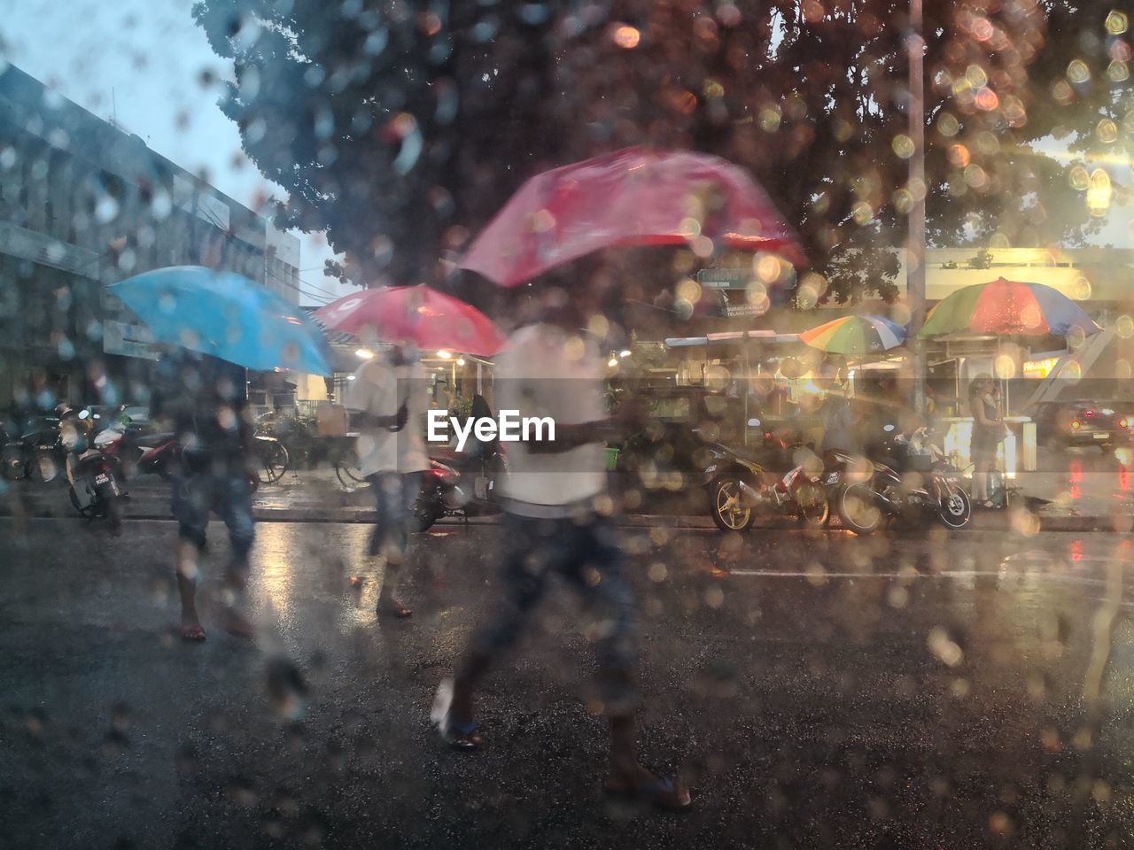 People seen through wet window in rainy season