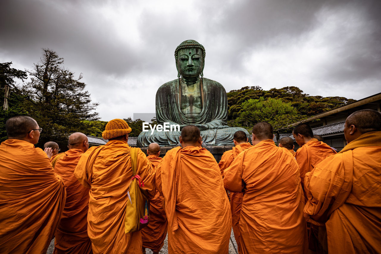 GROUP OF PEOPLE IN TEMPLE AGAINST SKY