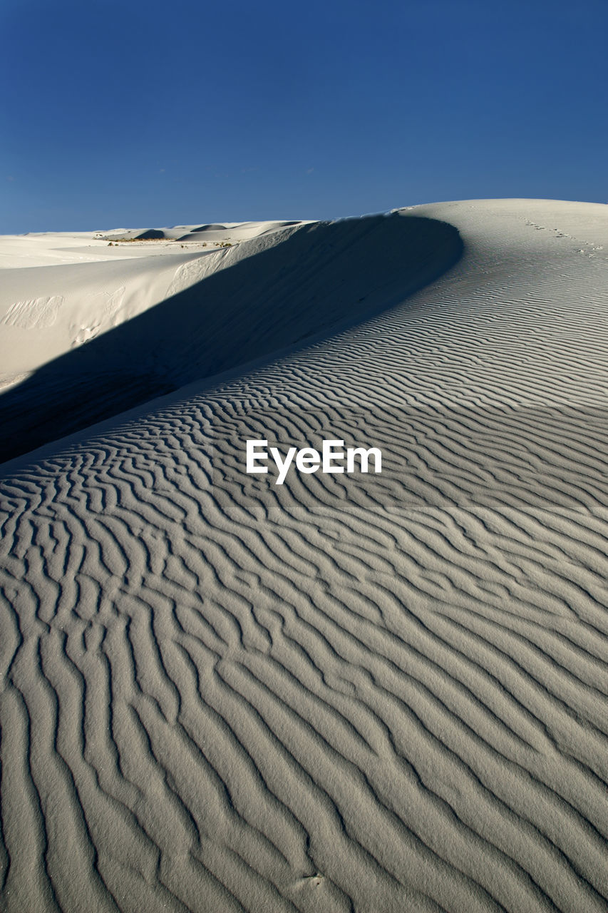 Sand dune in desert against sky