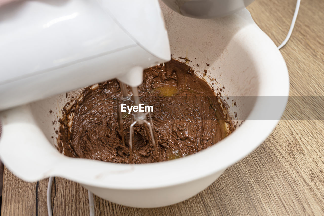 Mixing the dough with a hand mixer with a whisk with melted butter added, the dough is  thick mass.