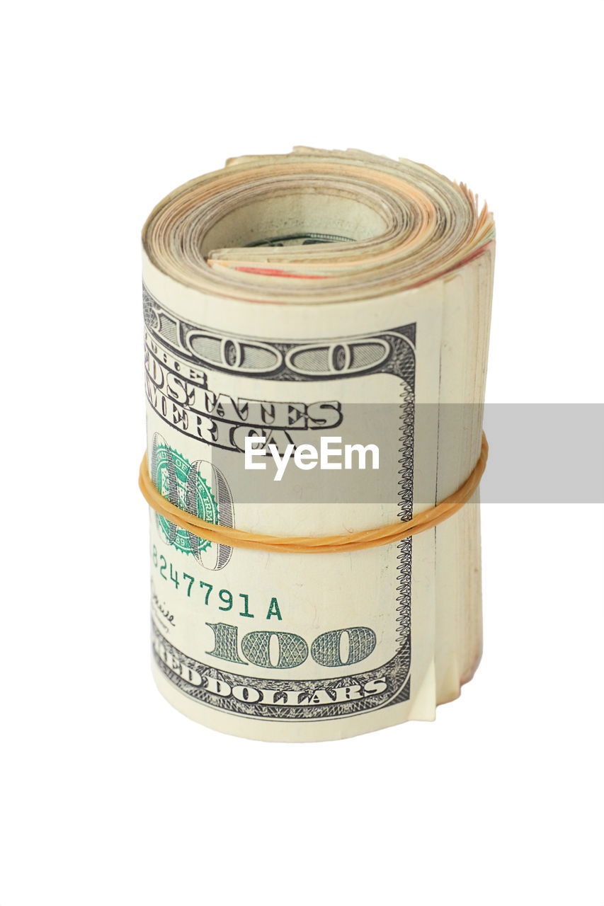 Close-up of rolled up paper currency on white background