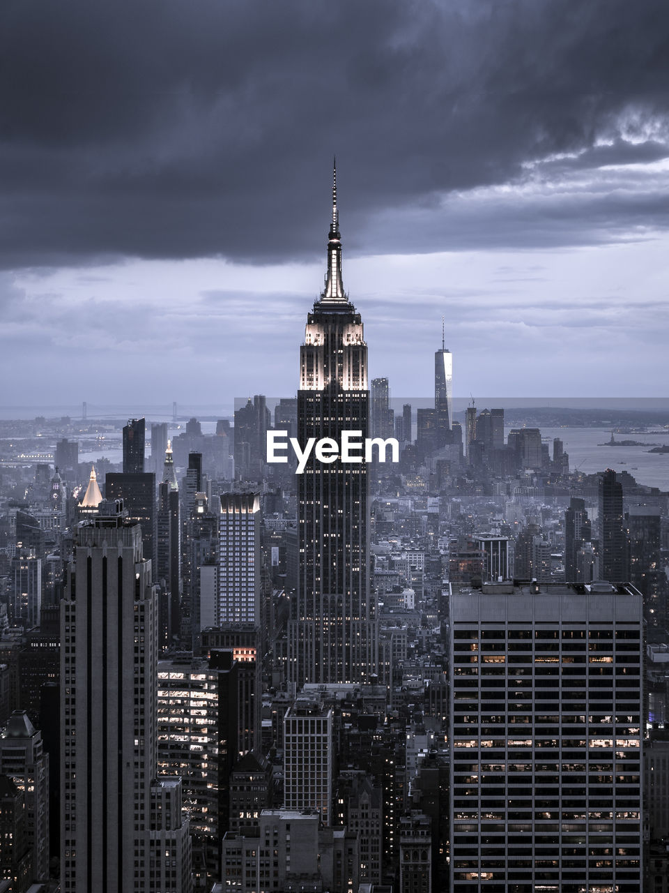 Modern buildings in city against cloudy sky