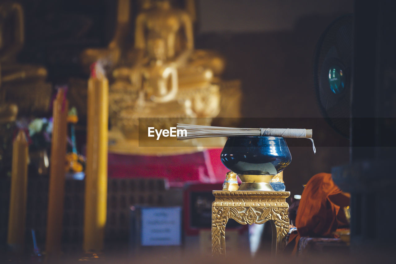 CLOSE-UP OF BUDDHA STATUE AT TEMPLE