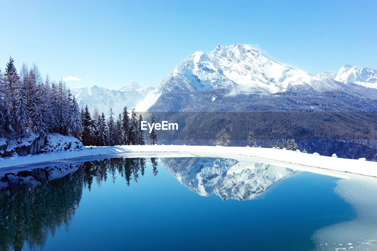 Scenic view of snow covered mountains against cloudy sky