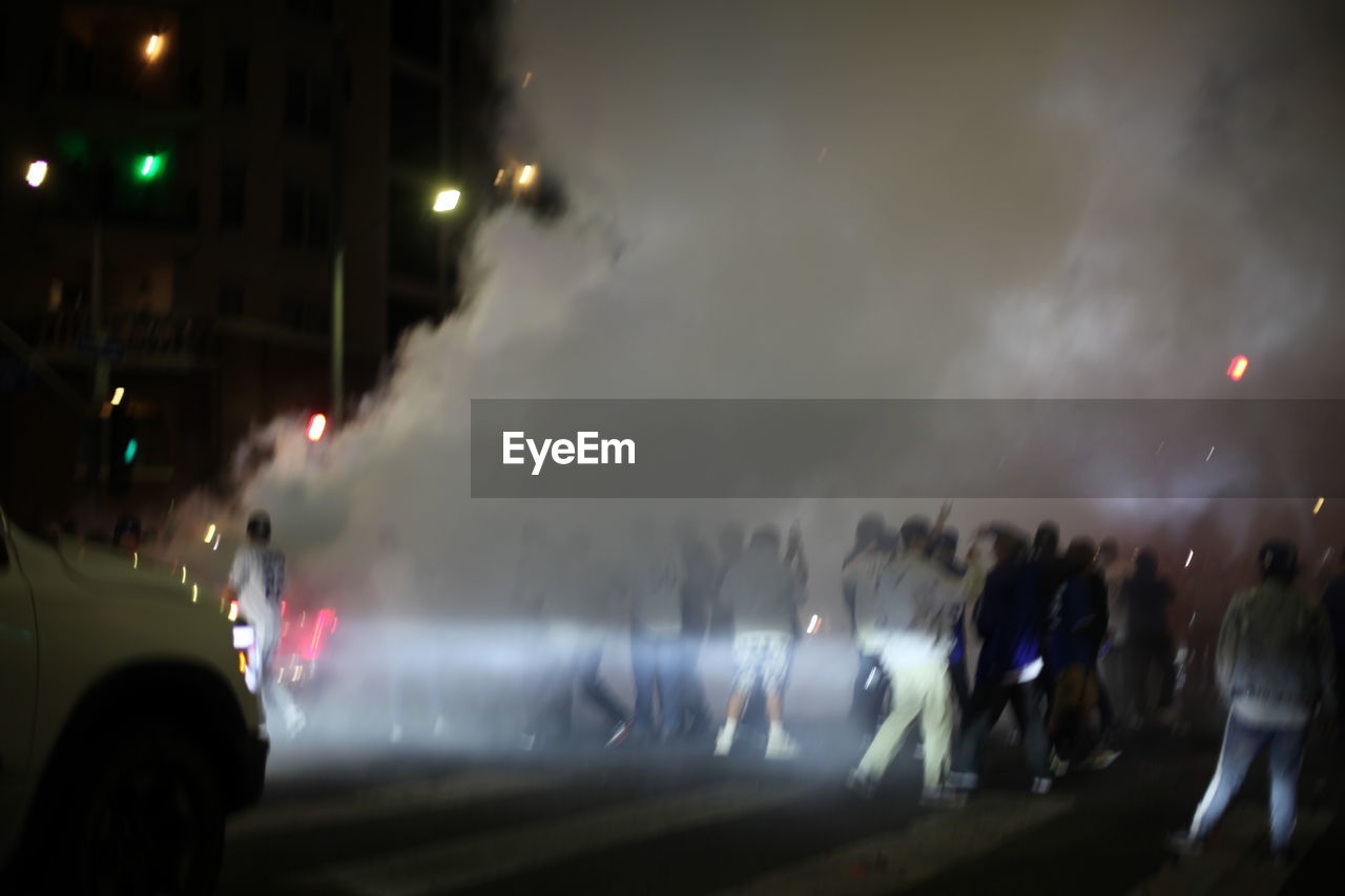 GROUP OF PEOPLE ON ROAD IN CITY