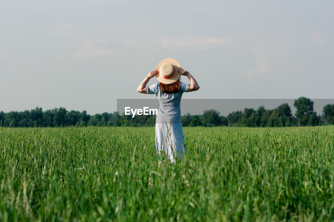 Woman in hat in the green field