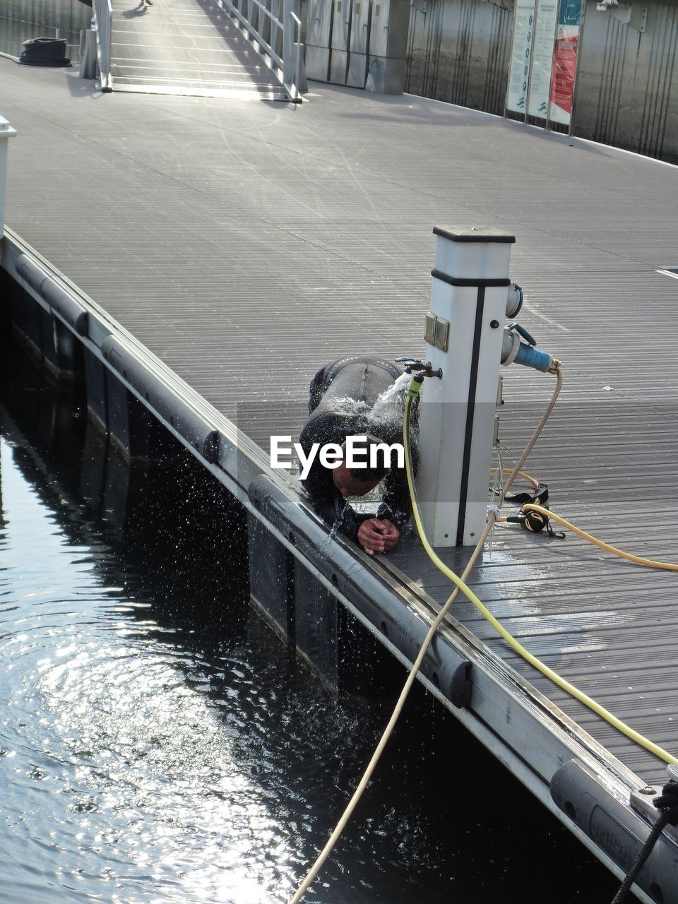 HIGH ANGLE VIEW OF MAN ON BOAT AT SHORE