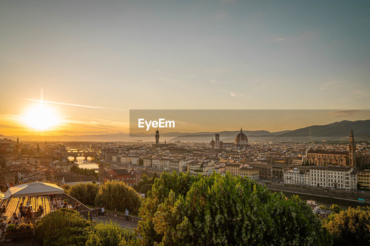 HIGH ANGLE VIEW OF BUILDINGS IN CITY AT SUNSET