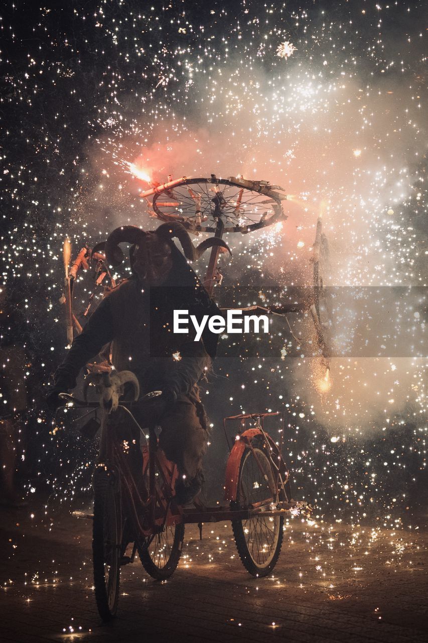 Bicycles parked in city at night fireworks at dimonis festival in majorca spain