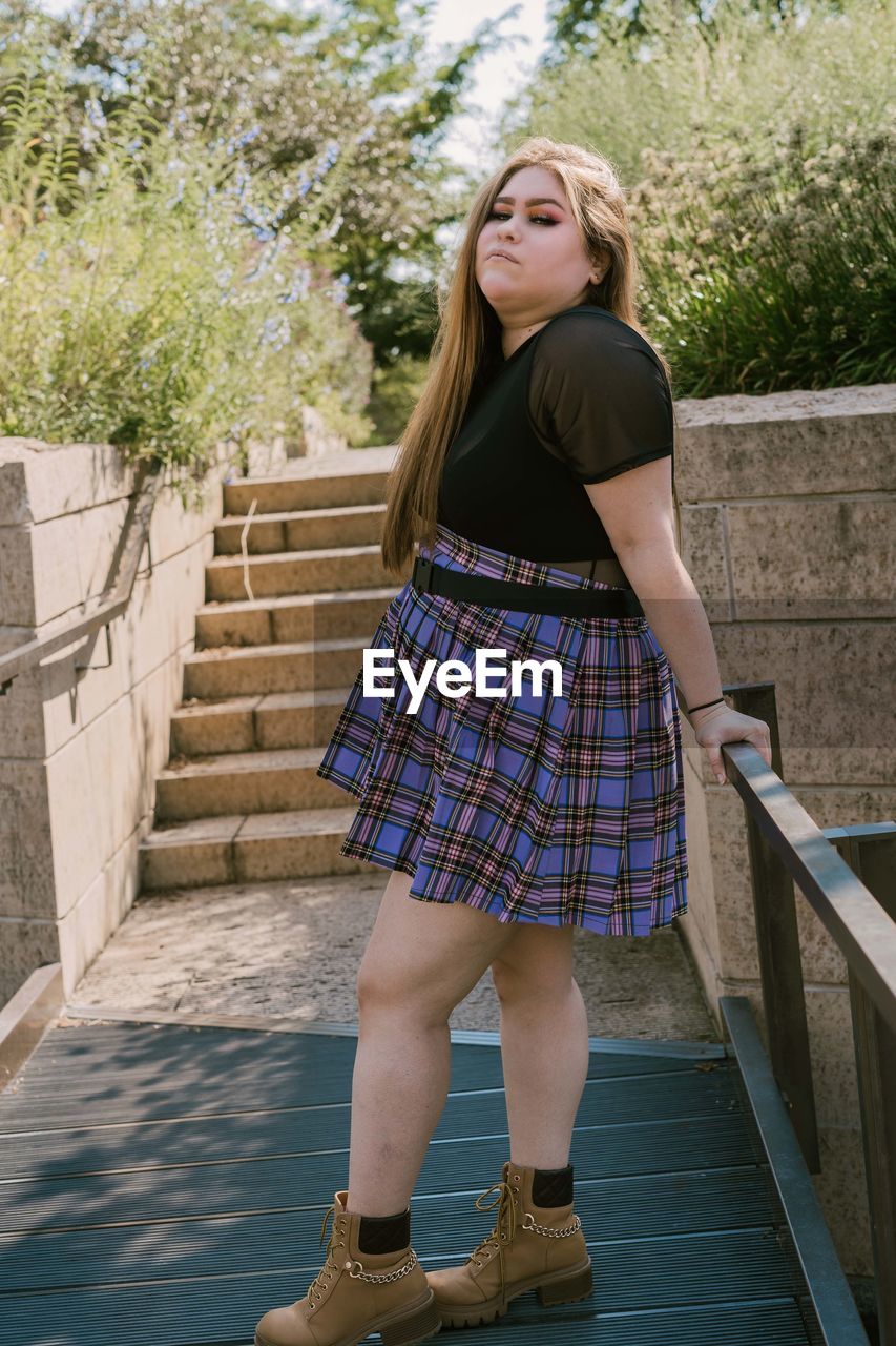 Portrait of teenage girl standing against staircase