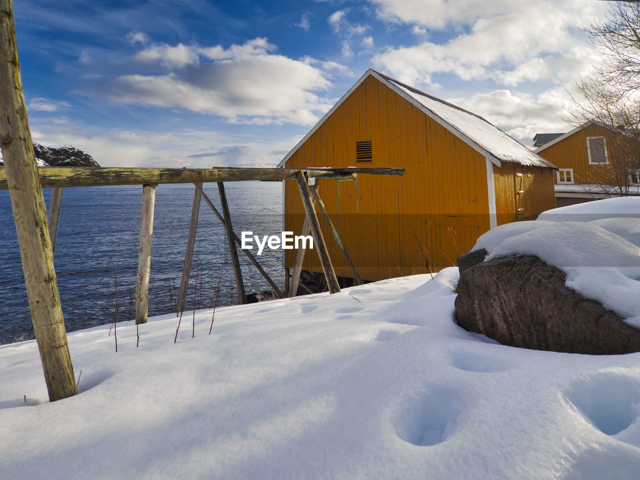 SNOW COVERED HOUSES AND BUILDINGS AGAINST SKY