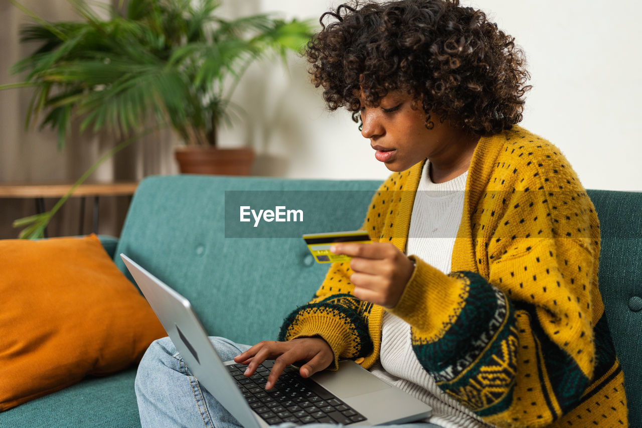 midsection of woman using laptop while sitting at home