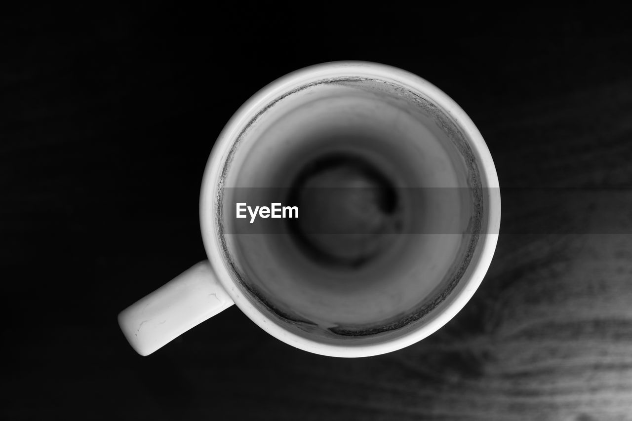 HIGH ANGLE VIEW OF COFFEE CUP ON TABLE AGAINST BLACK BACKGROUND