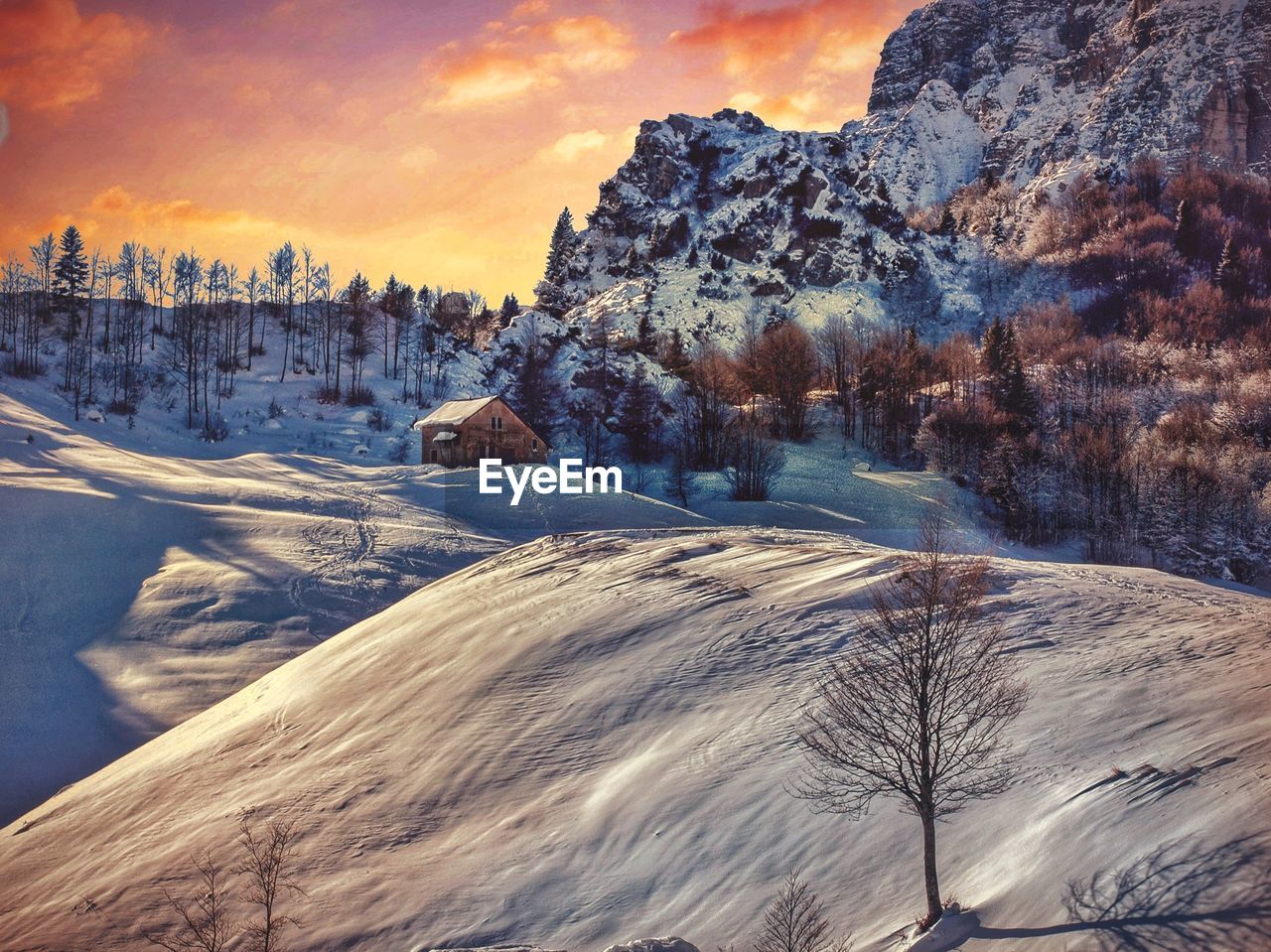 Scenic view of snow covered mountains against sky during sunset