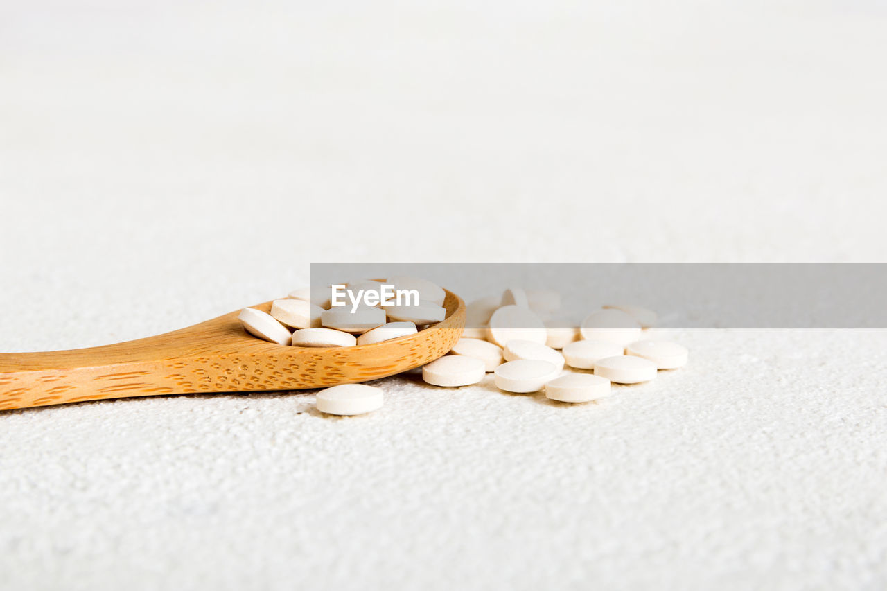 studio shot, pill, medicine, healthcare and medicine, indoors, dose, copy space, no people, spoon, food and drink, close-up, food, white background, wellbeing, still life, nutritional supplement, kitchen utensil, vitamin, capsule