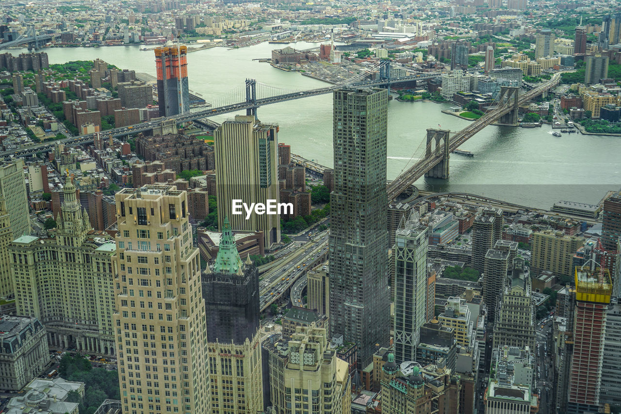 HIGH ANGLE VIEW OF MODERN BUILDINGS BY RIVER