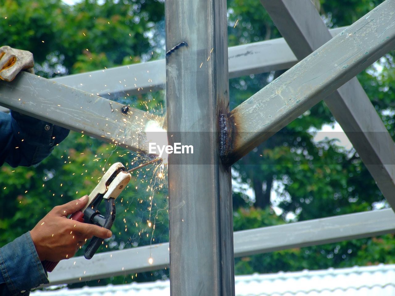 Cropped hands of welder welding metal