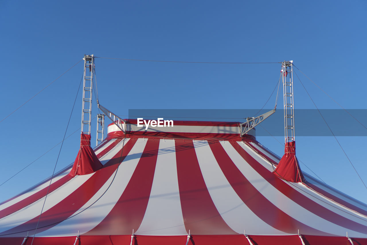 Low angle view of circus tent against clear blue sky