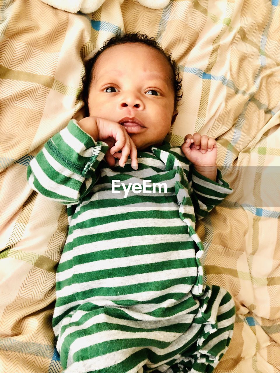 High angle view of baby boy lying on bed